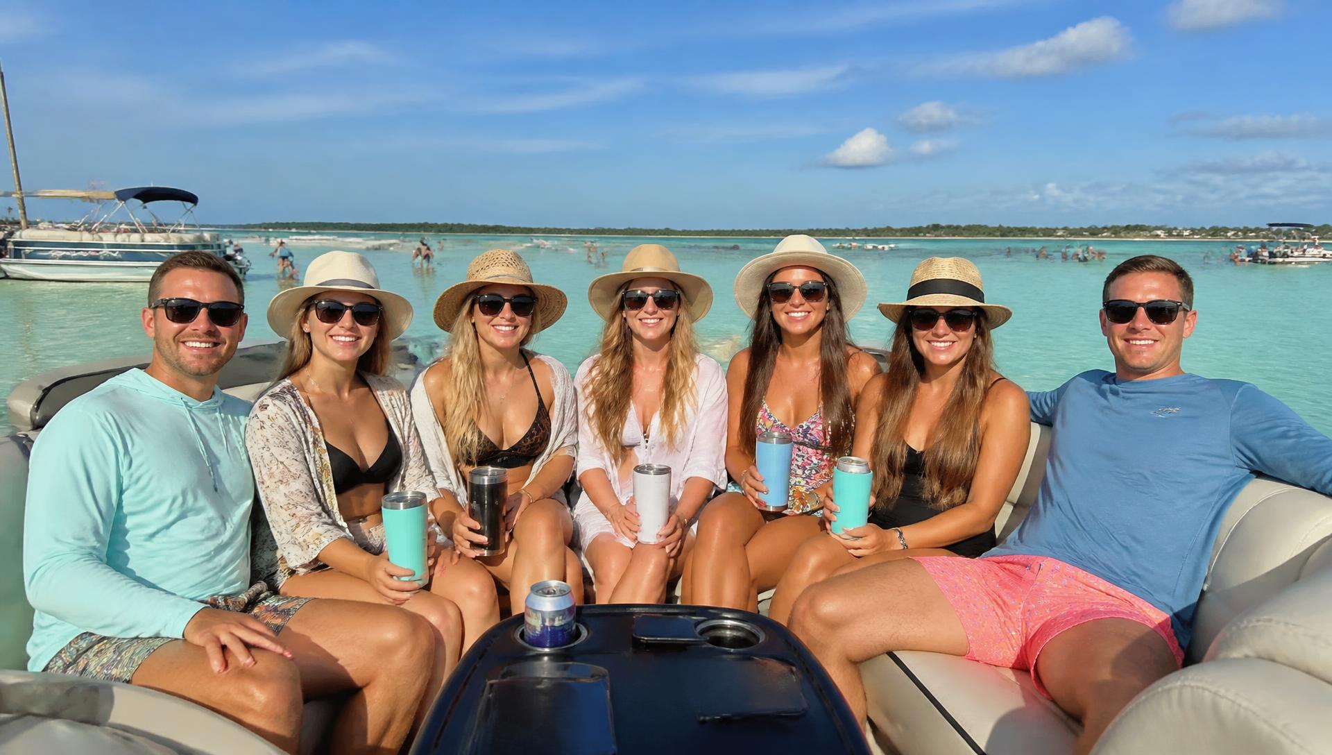 Group of friends relaxing on a rented pontoon boat charter at a Florida sandbar